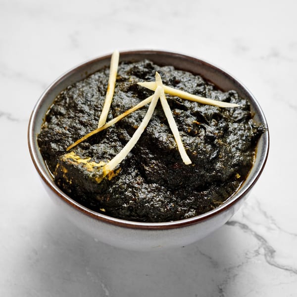 Masala Symphony's Palak Paneer, a rich green spinach curry with paneer cheese and ginger slivers.